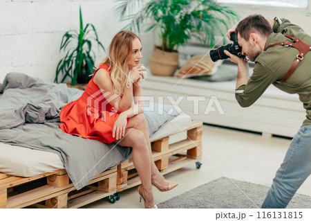 Photographer and beautiful model working together in modern studio Photographer and beautiful model working together in modern studio 116131815