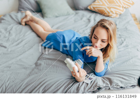Sexy fair-haired woman with DLSR camera in the bed. 116131849