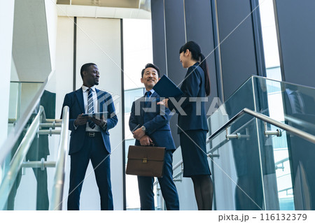 ロビーで会話する多国籍ビジネスパーソンのグループ 116132379