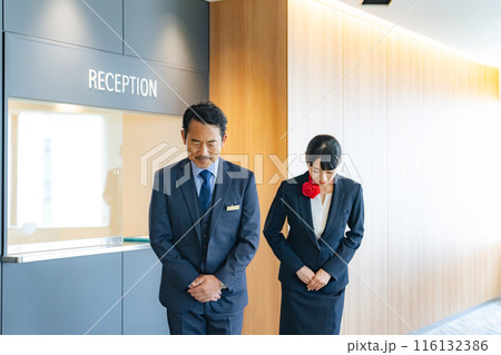 お辞儀するホテルフロントスタッフ 116132386