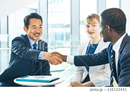 ロビーで握手する多国籍ビジネスパーソンのグループ 116132431