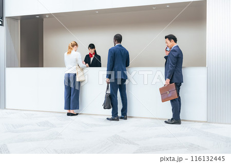 ホテルのフロントで手続きする多国籍の人々 ホテルのフロントで手続きする多国籍の人々 116132445