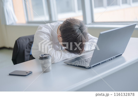 机に伏せるビジネスマン 116132878