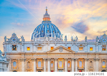 A scenic view of the iconic dome of St. Peters Basilica in Vatican City at sunset. The buildings facade and dome are illuminated by the warm glow of the evening light. A scenic view of the iconic dome of St. Peters Basilica in Vatican City at sunset. The buildings facade and dome are illuminated by the warm glow of the evening light. 116134101