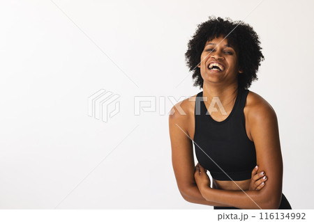 Biracial woman laughing in studio, wearing black sportswear, copy space Biracial woman laughing in studio, wearing black sportswear, copy space 116134992