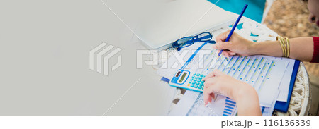 Banner woman working office desk reading financial report finance chart graph on table. Wide tax audit woman hands working paperwork office. Banner Businesswoman Audit financial with copy space 116136339