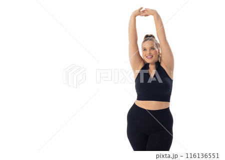 A Caucasian plus size model on white background stretches her arms up, copy space A Caucasian plus size model on white background stretches her arms up, copy space 116136551