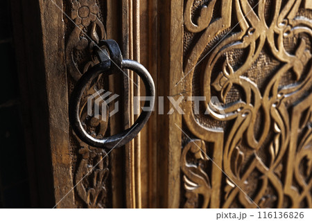 Vintage round handle on an old oriental wooden door Vintage round handle on an old oriental wooden door 116136826