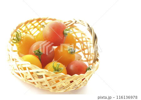 竹かごに沢山入っている黄色と赤色のミニトマトを白背景で撮影 116136978