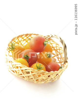 竹かごに沢山入っている黄色と赤色のミニトマトを白背景で撮影 116136995