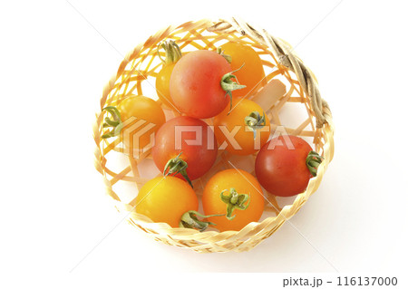 竹かごに沢山入っている黄色と赤色のミニトマトを白背景で撮影 116137000