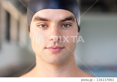 Caucasian boy with brown hair, green eyes in black cap stands indoors near water Caucasian boy with brown hair, green eyes in black cap stands indoors near water 116137061