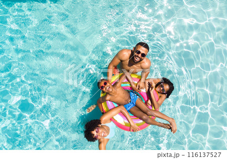 Diverse family enjoys a sunny day in the pool 116137527