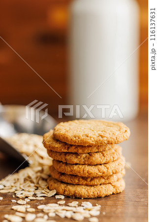 Tasty oatmeal cookies and rolled oat on wooden table. Tasty oatmeal cookies and rolled oat on wooden table. 116137631