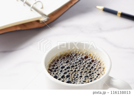 淹れたてのコーヒーを飲みながら、リング式のシステム手帳を開いて、仕事の段取りを考えているイメージ 淹れたてのコーヒーを飲みながら、リング式のシステム手帳を開いて、仕事の段取りを考えているイメージ 116138013