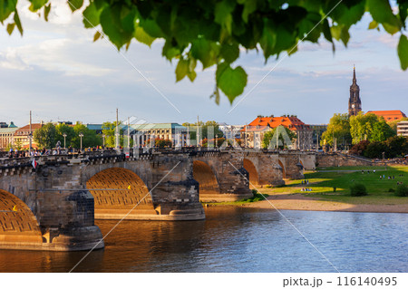 Scenic cityscape Dresden old center view Bruhl terrace balcony  Augustus Elbe river bridge against sunset blue cloud sky. People walking central square at Holy Trinity church at Saxony Germany 116140495