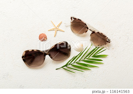 sunglasses with seashell lying on table background. Sunglasses on summer background. Top view flat lay with copy space for text sunglasses with seashell lying on table background. Sunglasses on summer background. Top view flat lay with copy space for text 116141563