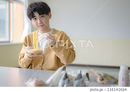 麺を持ち上げる若い男性 116141684