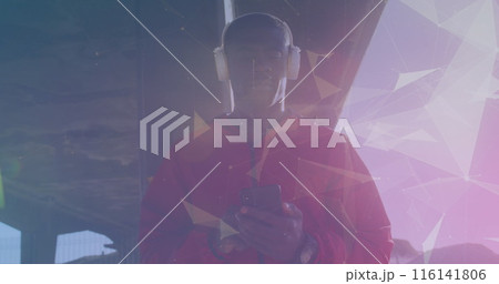 African American male athlete wearing headphones, holding smartphone 116141806