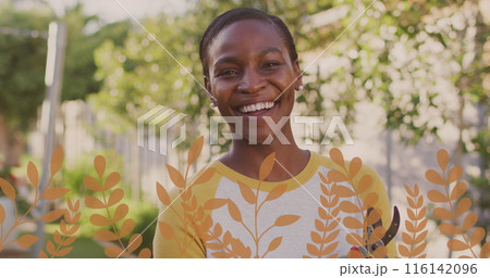 African American woman standing outdoors, wearing yellow shirt, smiling 116142096