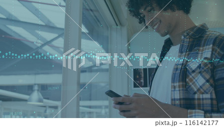 A young biracial chef with curly black hair and beard is looking at a smartphone A young biracial chef with curly black hair and beard is looking at a smartphone 116142177