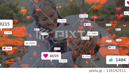 Caucasian senior woman is hugging large dog, both outdoors 116142511