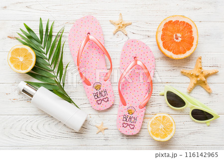Top view composition of flip flops placed with beach accessories top view on table background. Tropical summer vacation concept Flat lay Top view composition of flip flops placed with beach accessories top view on table background. Tropical summer vacation concept Flat lay 116142965