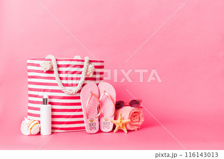 Stylish bag with beach accessories . Summer holiday concept. Top view of beach bag with sunscreen cream with space for text 116143013