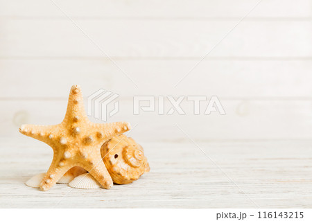Summer time concept with sea shells or starfish on a table background with copy space for text Summer time concept with sea shells or starfish on a table background with copy space for text 116143215