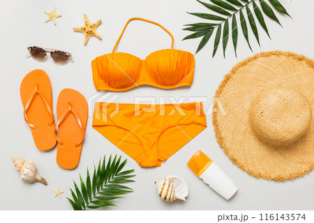 Woman swimwear and beach accessories flat lay top view. Top view with bikini outfit on color background. Vacation concept copy space 116143574