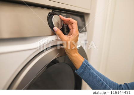 House wife preparing a washing machine for clothes washing 116144451