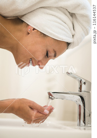 Woman washing her face in the morning 116144537