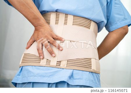 Asian lady patient wearing back pain support belt for orthopedic lumbar with walker. Asian lady patient wearing back pain support belt for orthopedic lumbar with walker. 116145071