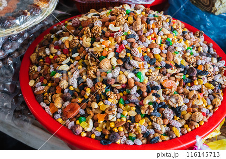 traditional Uzbek sweet mix of various varieties of nuts, dried fruits, oriental sweets on counter in eastern bazaar closeup 116145713