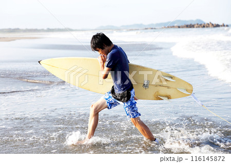 サーフィンを楽しんで海から上がる少年 116145872