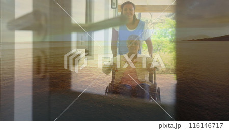 Biracial nurse assisting biracial senior patient in wheelchair by large window Biracial nurse assisting biracial senior patient in wheelchair by large window 116146717