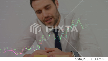 Caucasian male in suit checking his watch, with stock market graphs overlay 116147480