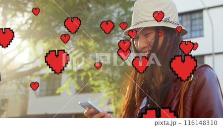 Asian woman wearing hat, checking her smartphone, has long black hair Asian woman wearing hat, checking her smartphone, has long black hair 116148310