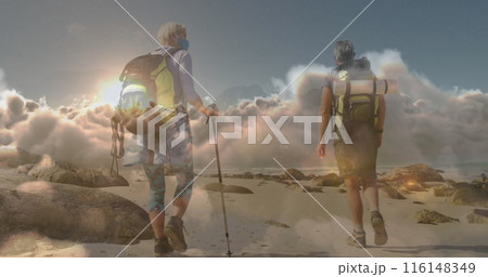 Caucasian couple hiking on rocky beach, carrying backpacks Caucasian couple hiking on rocky beach, carrying backpacks 116148349