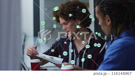 Image of globe of digital icons over two diverse male office colleagues discussing over document 116148967