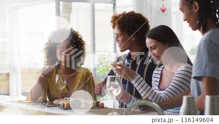 Image of white spot lights over diverse friends having drink in bar Image of white spot lights over diverse friends having drink in bar 116149604