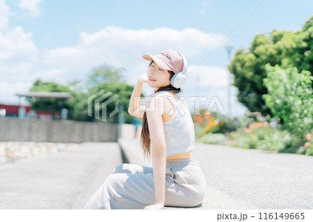 屋外で音楽を聴く若い女の子 屋外で音楽を聴く若い女の子 116149665