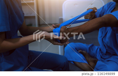 Professional physical therapist examines and cares for a young man in a physical therapy center, treating muscles and injuries of a man in a hospital. 116149899
