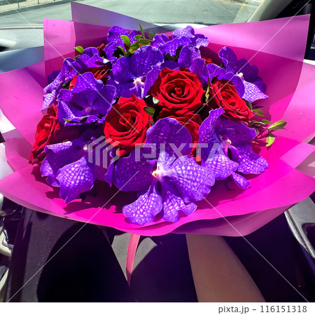 Bright colorful bouquet of red roses and purple orchids 116151318