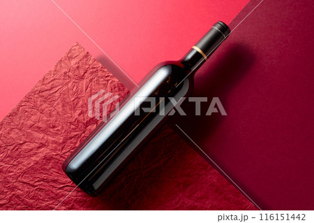 Bottle of red wine on a red background. Bottle of red wine on a red background. 116151442