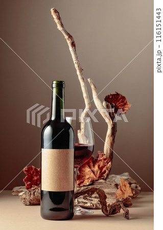 Bottle and glass of red wine with a composition of old wood. 116151443