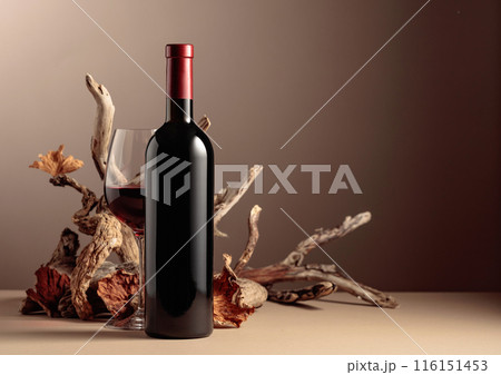 Bottle and glass of red wine with a composition of old wood. 116151453