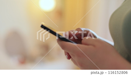 Woman using texting mobile phone or chat in home morning. Close up of young woman hand. Technology, communication concept. Woman using texting mobile phone or chat in home morning. Close up of young woman hand. Technology, communication concept. 116152806