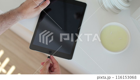 Man hands plugging a charger in a Tablet computer. Mobile charging. Man hands plugging a charger in a Tablet computer. Mobile charging. 116153068