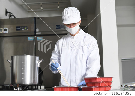 弁当箱に料理を詰める男性の調理スタッフ 116154356